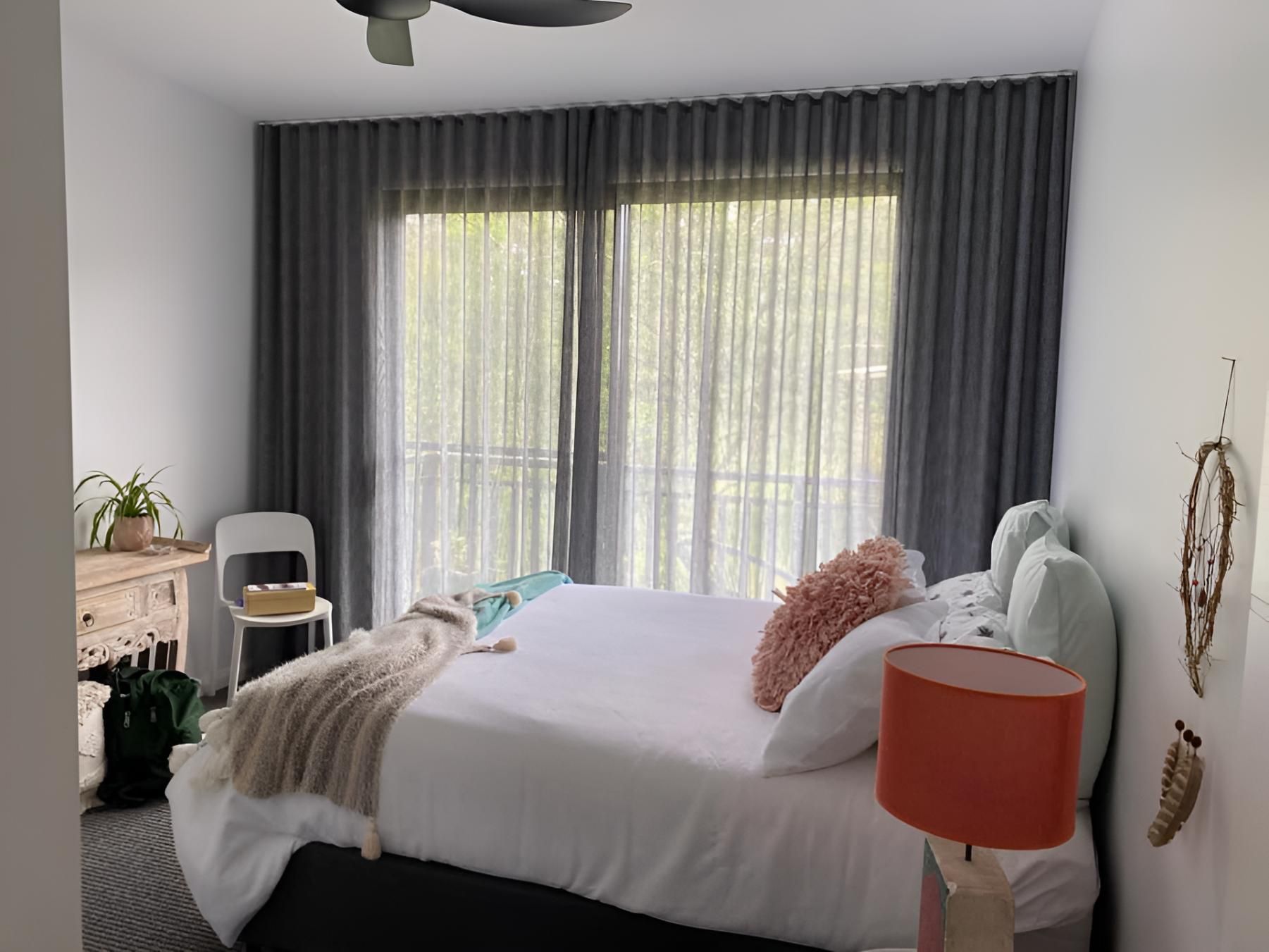 A Bedroom With a Large Bed, a Lamp, and a Ceiling Fan — Lismore Curtains & Blinds In Casino, NSW