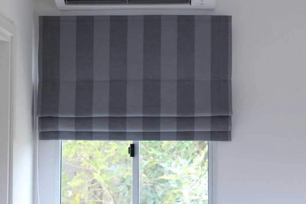 There is a Window With a Striped Roman Shade on It — Lismore Curtains & Blinds In Lismore, NSW