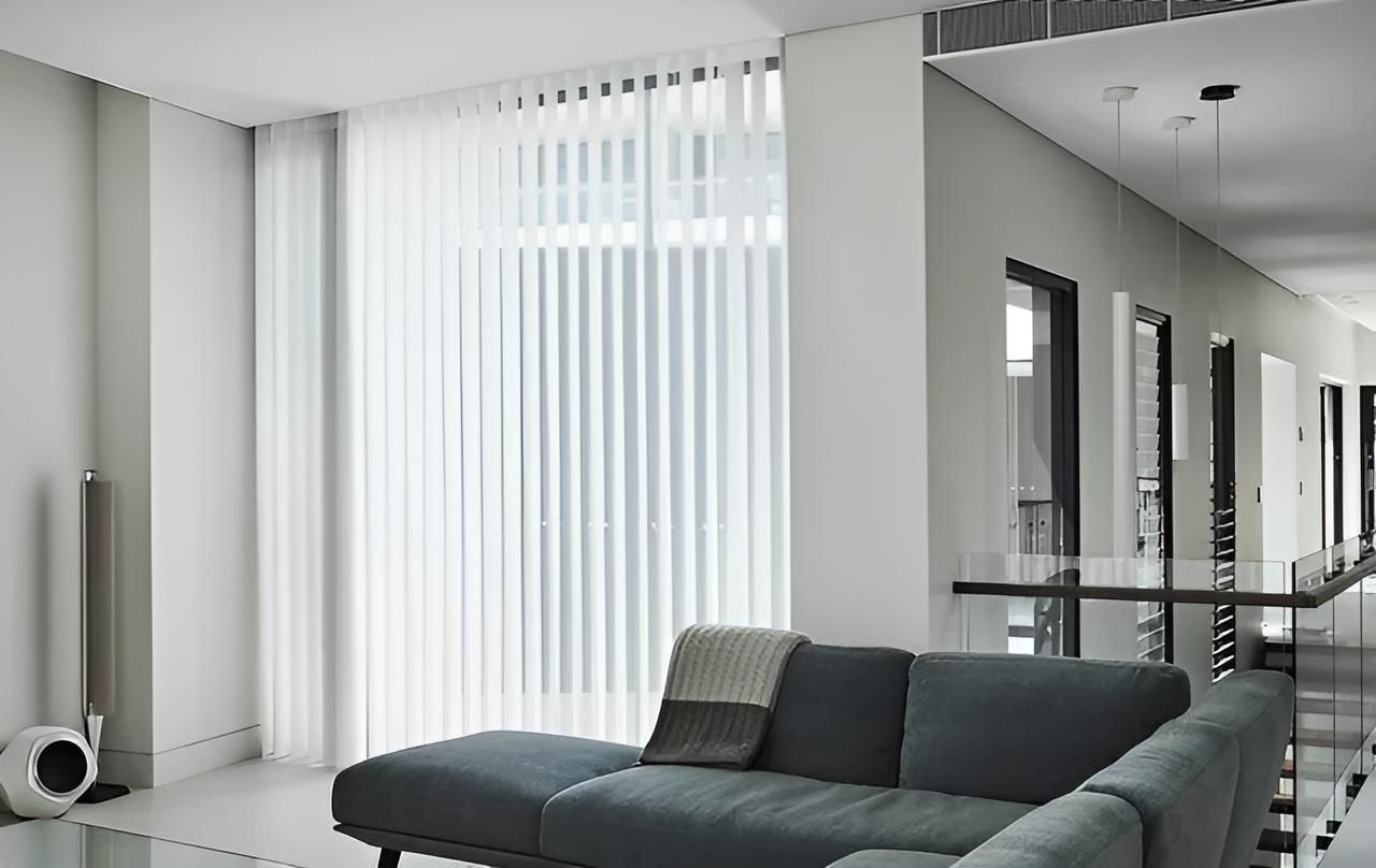A Living Room With a Couch and White Vertical Blinds — Lismore Curtains & Blinds In Lismore, NSW