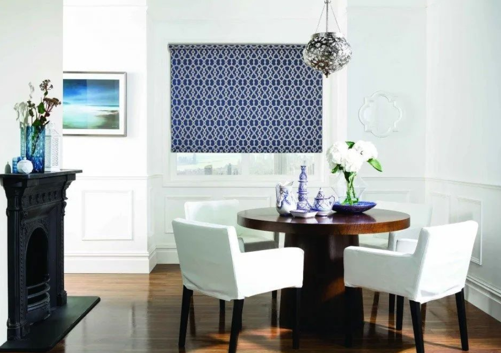 Elegant dining room featuring a navy blue geometric-patterned roller blind on a large window.