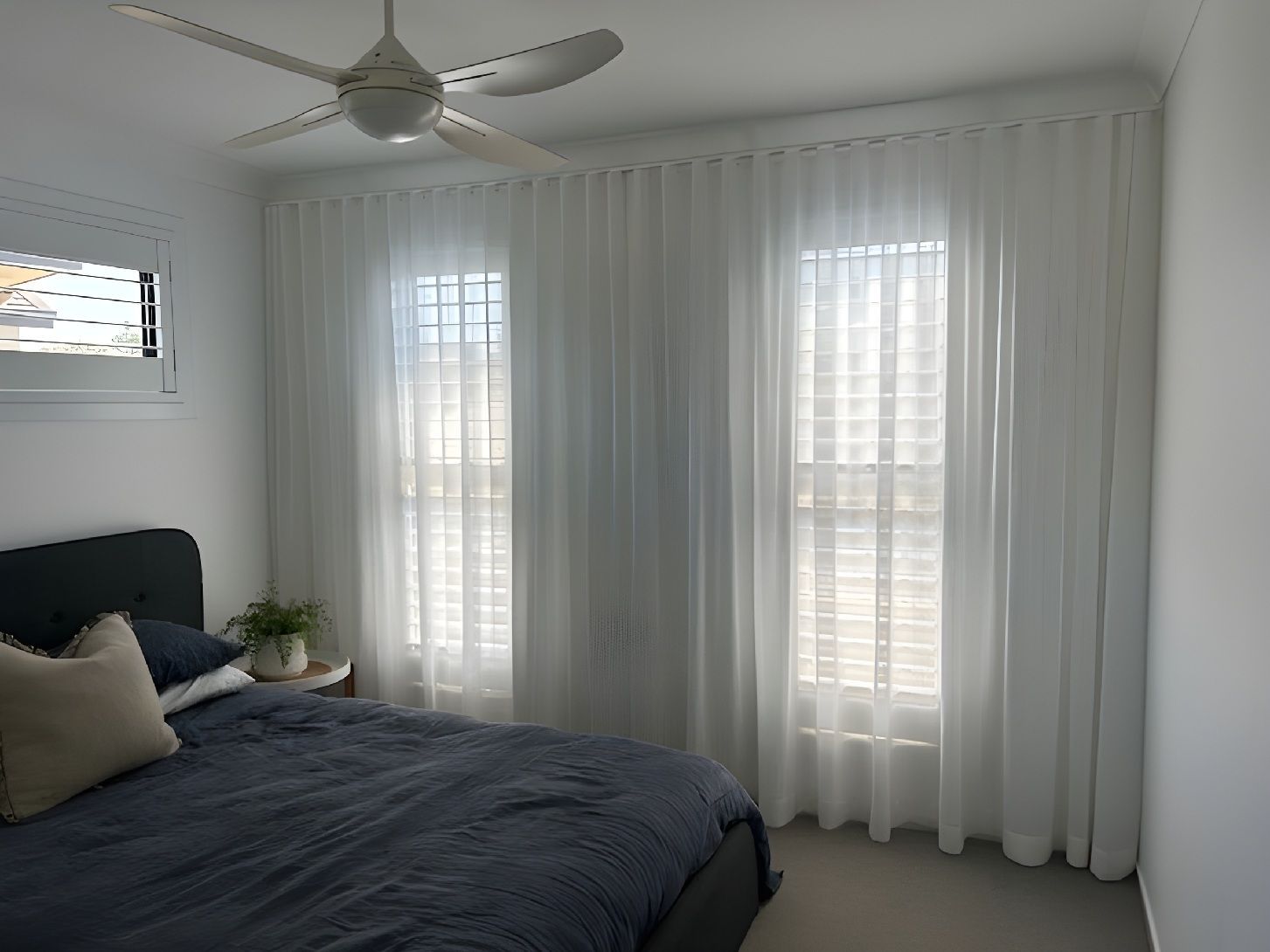 Sheer White Curtains Covering Bedroom Windows With Soft Daylight