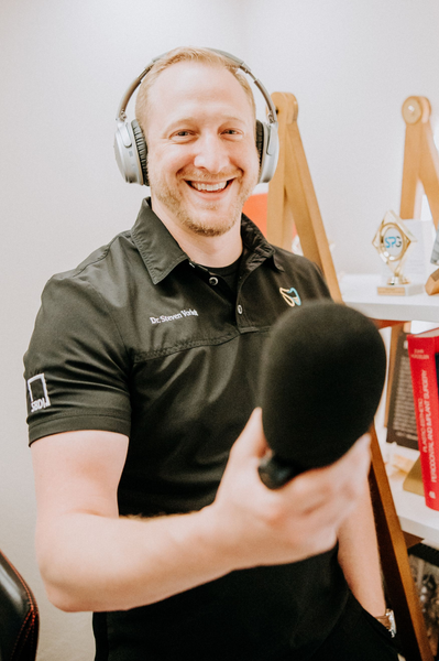 Steven Vorholt smiling with a podcast microphone and headset.
