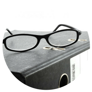 A pair of glasses rests on top of a binder