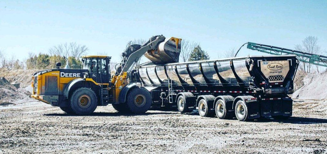 Live Bottom trailer being loaded with a tractor front-end loader