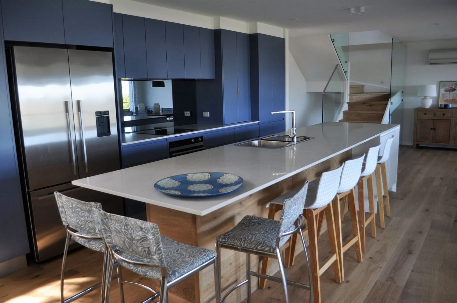A Kitchen With a Large Island and a Stainless Steel Refrigerator — The Kitchen Centre In Tuggerah, NSW