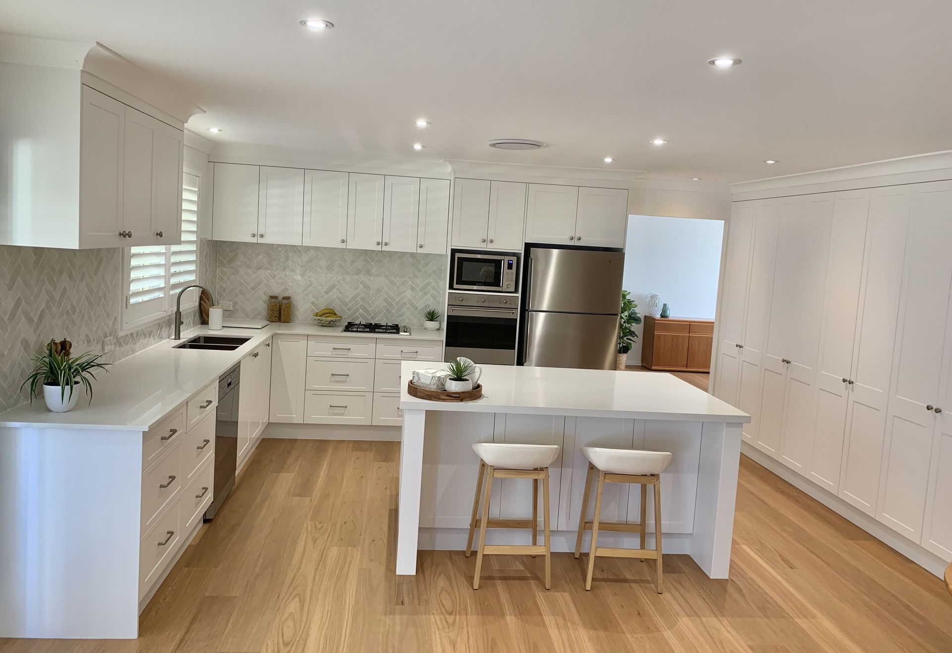 Modern White Kitchen With Island and Stools — The Kitchen Centre In Tuggerah, NSW