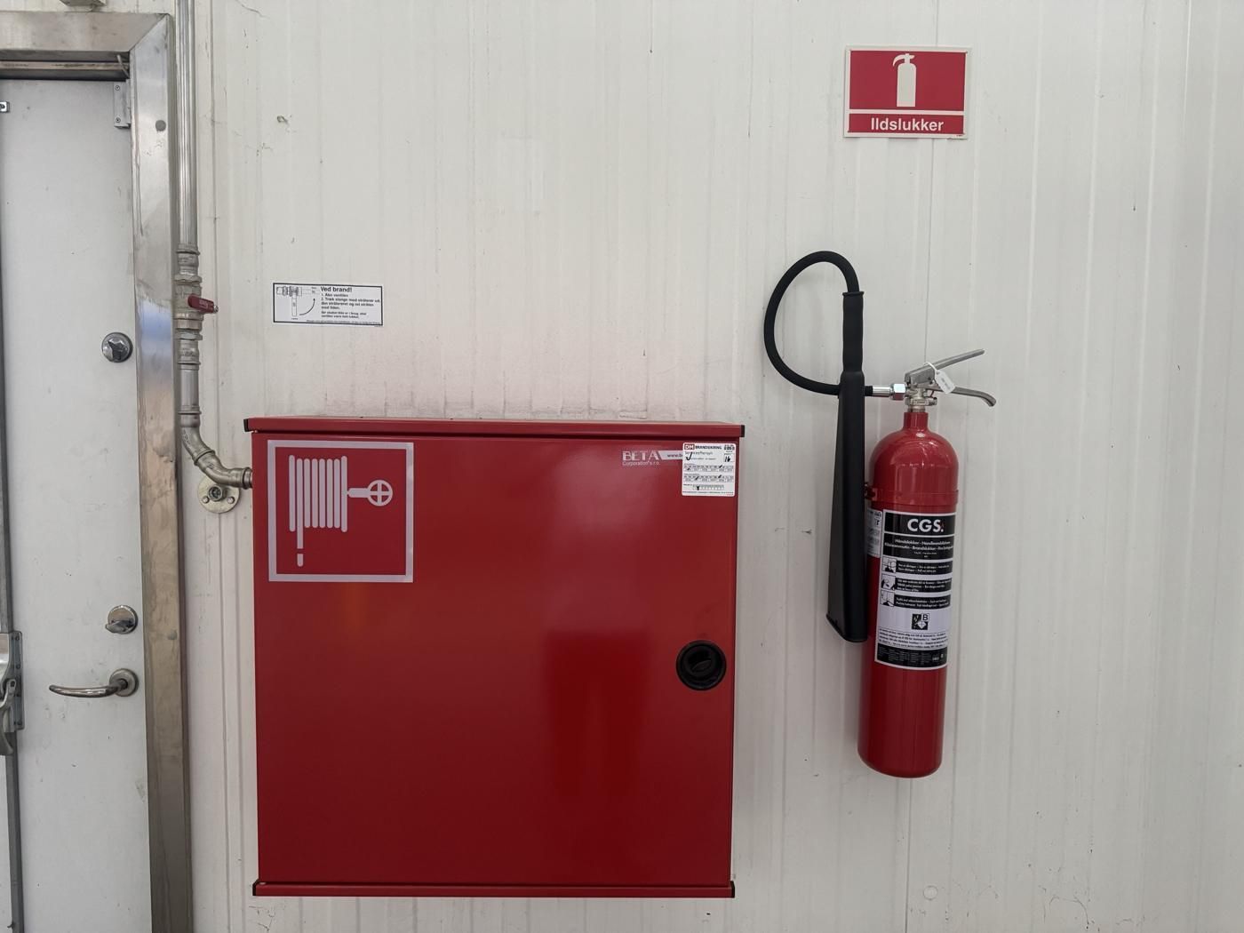 Brandslangeskab med DM-servicelabel og CO₂-slukker