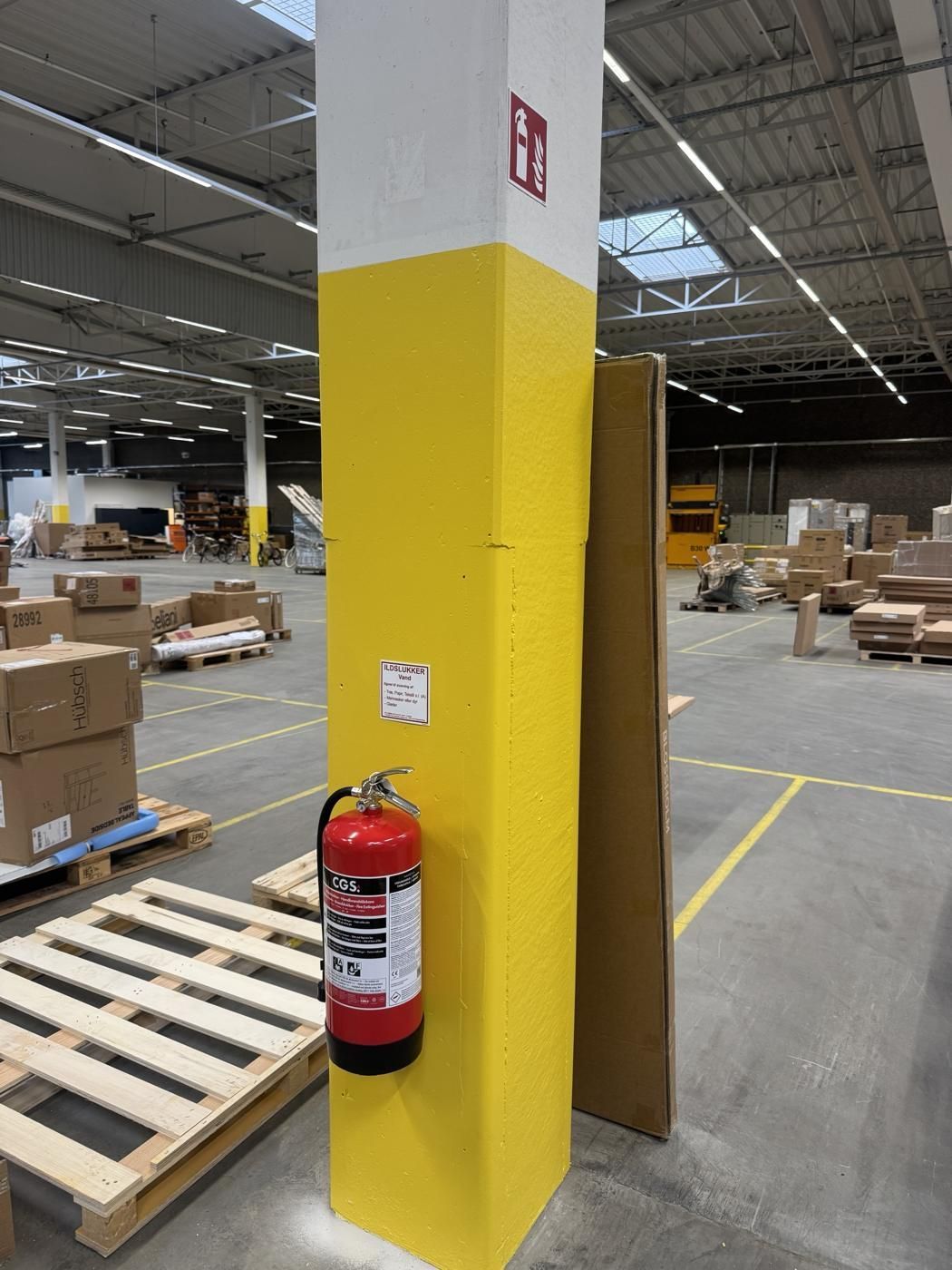 Vandslukker monteret på søjle i lagerhallen