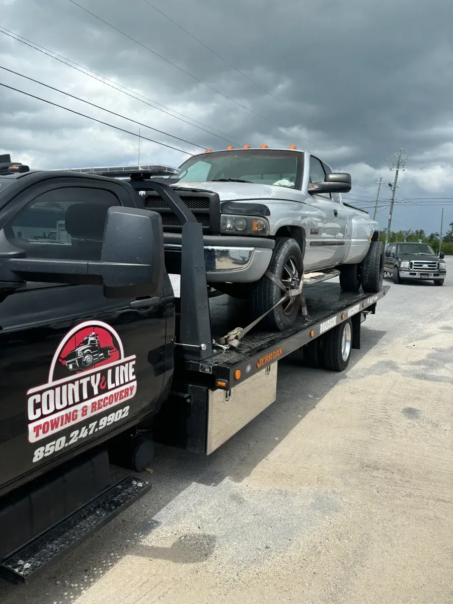Two trucks are being towed by a tow truck.