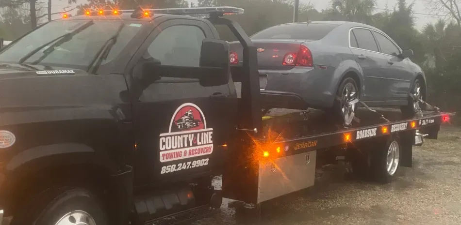 A car is being towed by a tow truck.