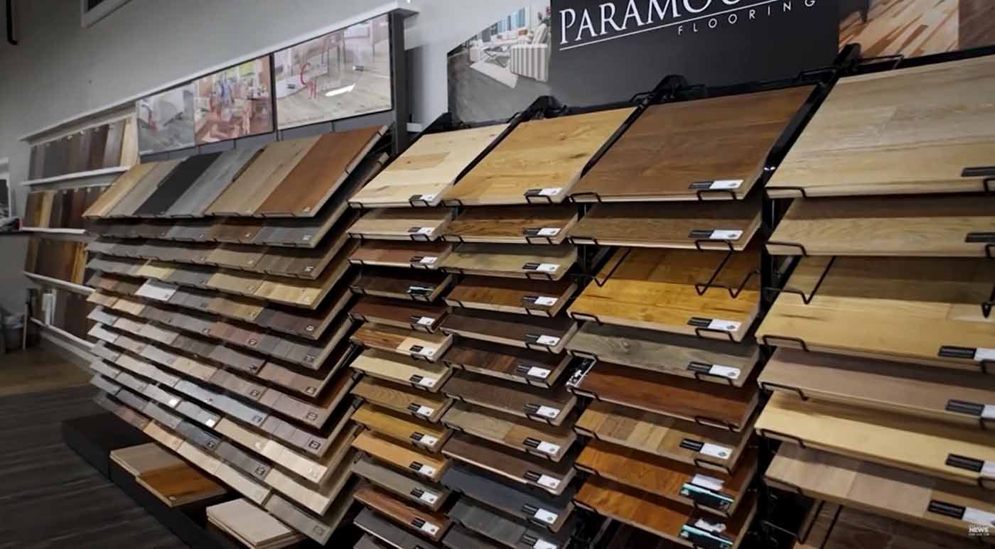 Flooring showroom with rows of wood and laminate sample planks on display racks