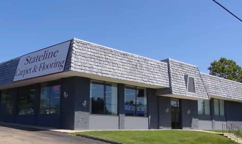 Corner storefront of Satellite Sports & Running with blue windows and shingled roof under a clear sky