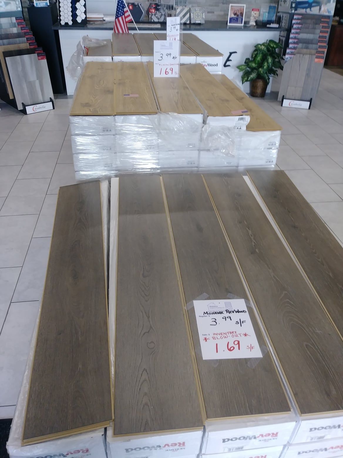 Store display of stacked laminate flooring samples in gray and brown tones.