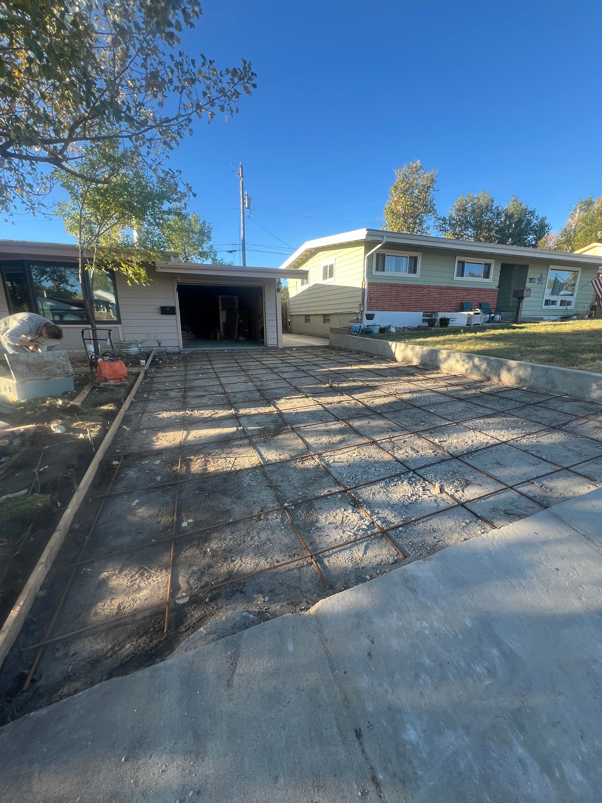 A concrete driveway is being built in front of a house.