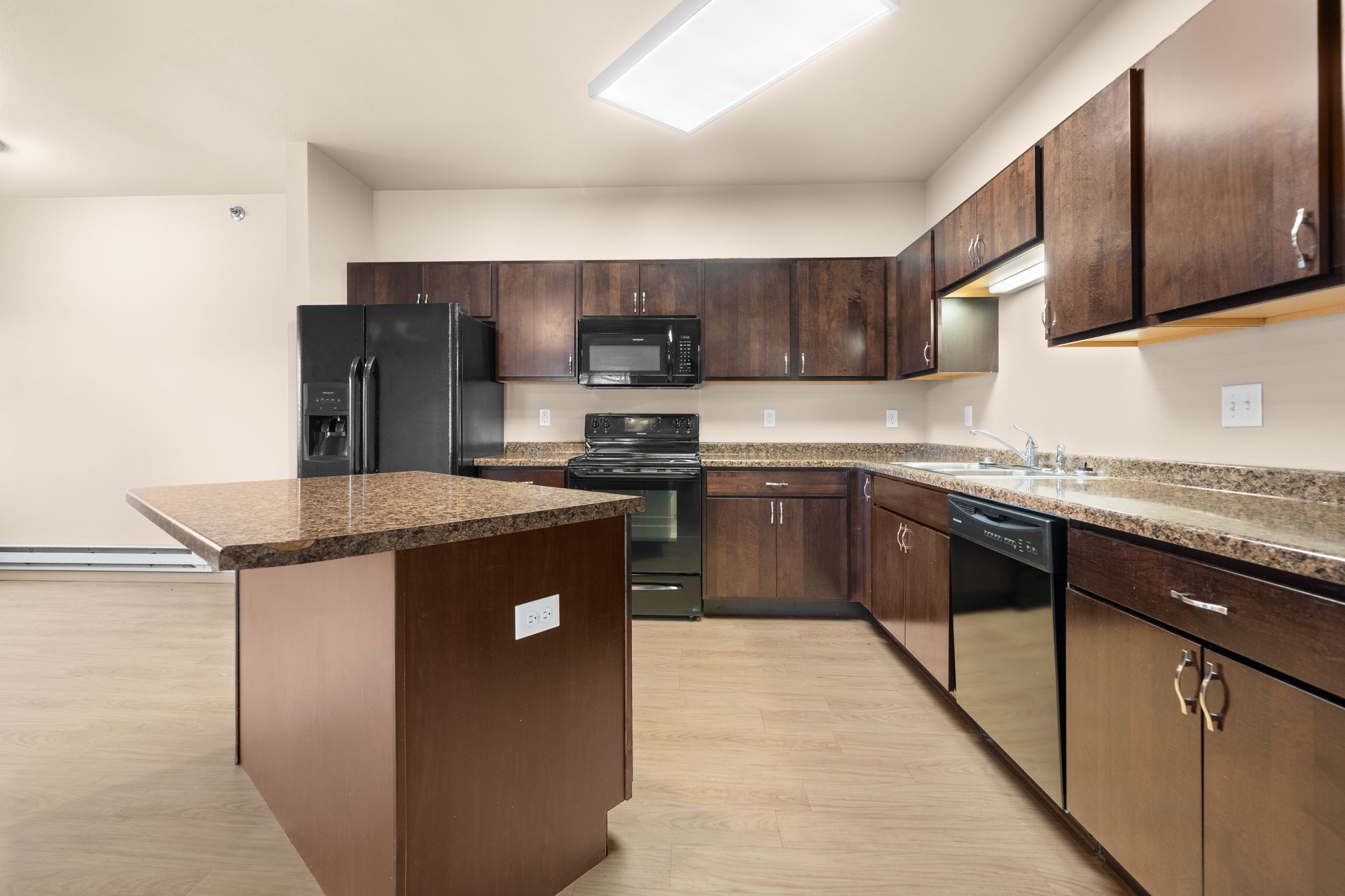 Stonebridge Villas Kitchen with Dark Paneled Wood Cabinets