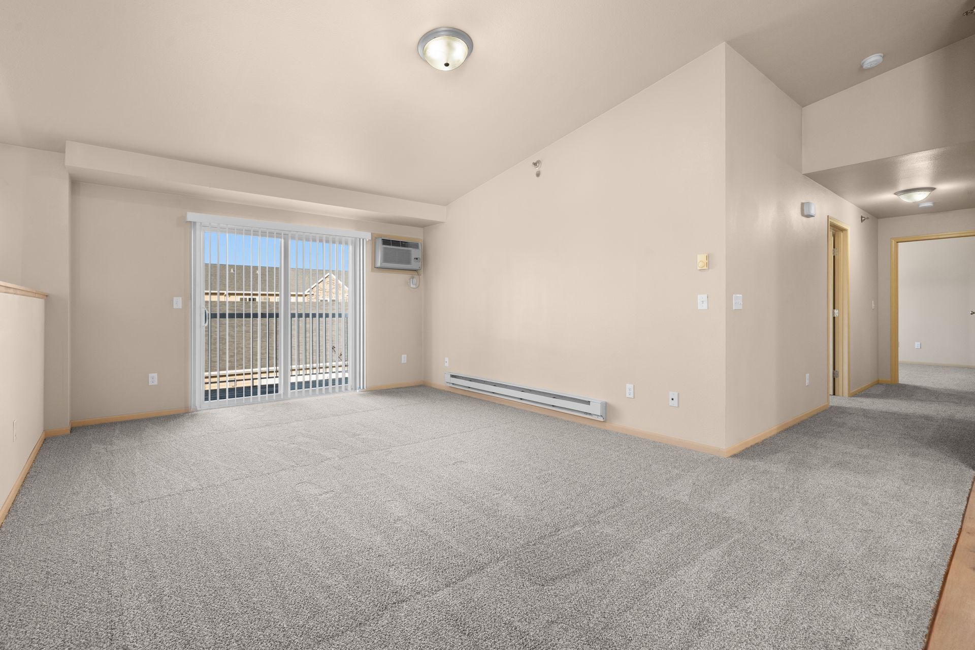 Stonebridge Villas Second Floor Unit with Empty Spacious Living Room and Sliding Glass Door