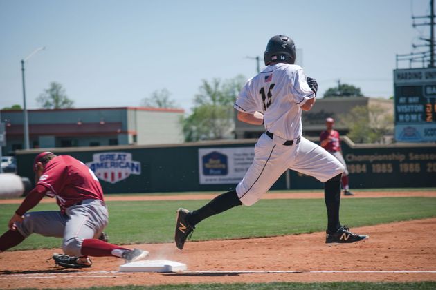 Baseball on a dark surface, with visible stitching.