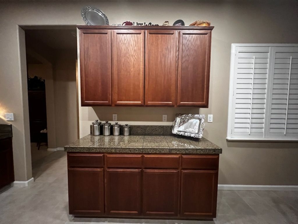 A kitchen with wooden cabinets and a granite counter top.