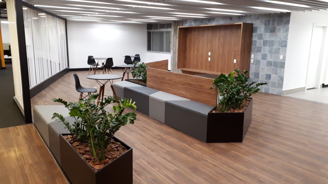 Hall de entrada moderno com piso de madeira, plantas em vasos, mesas e parede revestida de madeira [0m