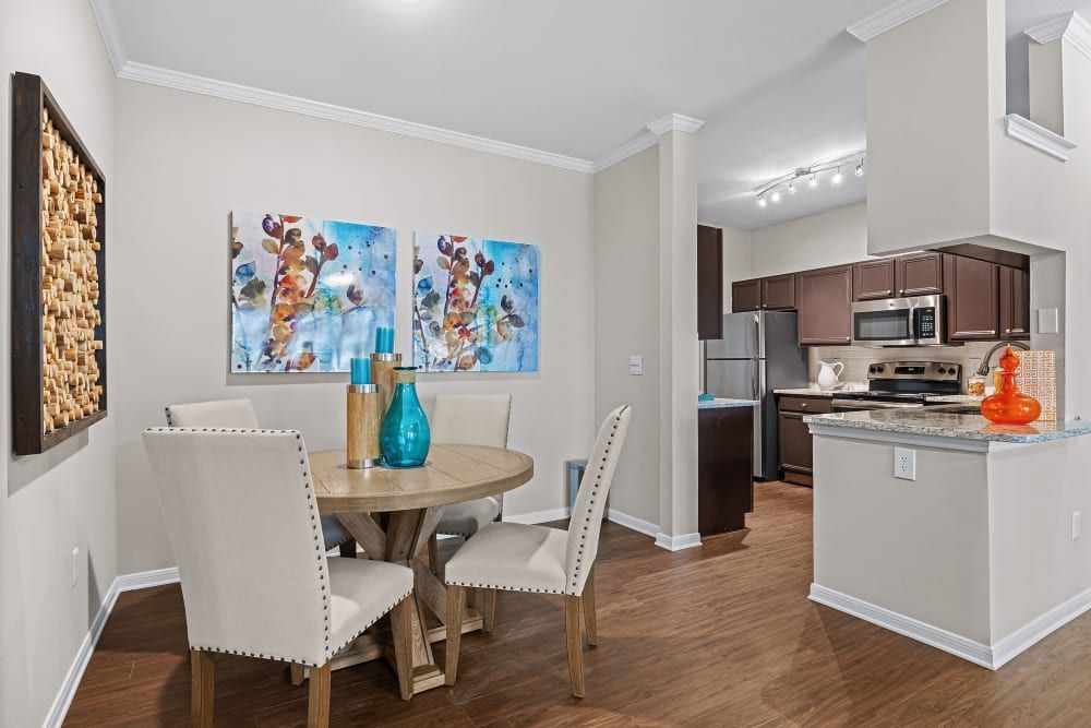 a dining room with a round table and chairs next to a kitchen at Marquis at Ladera Vista in Austin, TX.