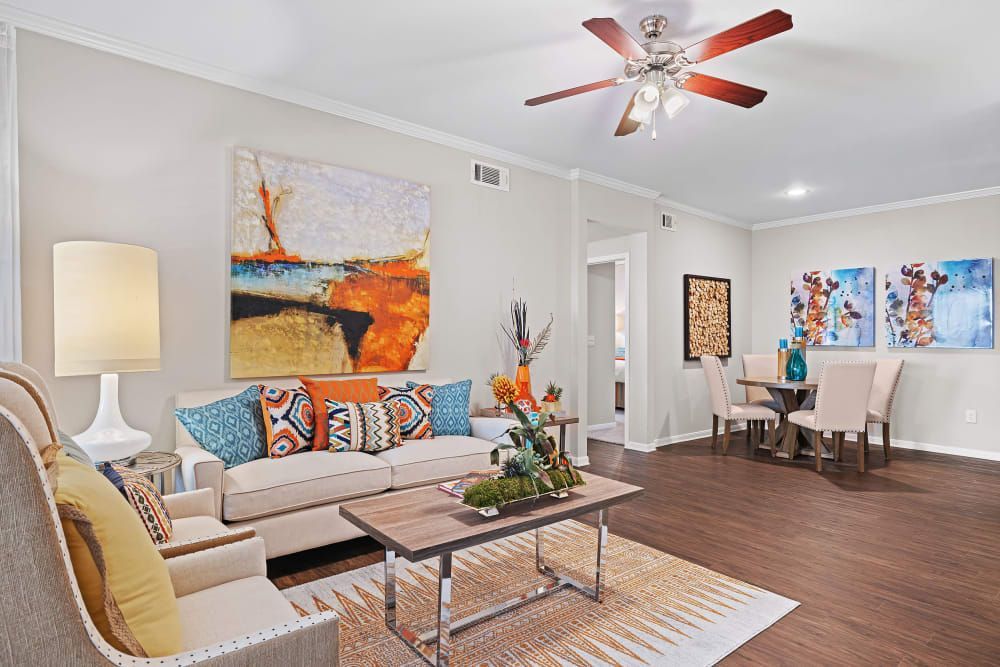 a living room with a couch, chairs, coffee table, and ceiling fan at Marquis at Ladera Vista in Austin, TX.
