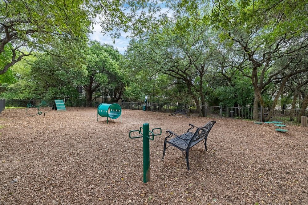 a bench in the middle of the park at Marquis at Ladera Vista in Austin, TX.
