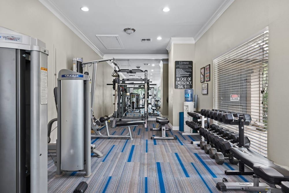 a large gym filled with lots of exercise equipment and dumbbells at Marquis at Ladera Vista in Austin, TX.