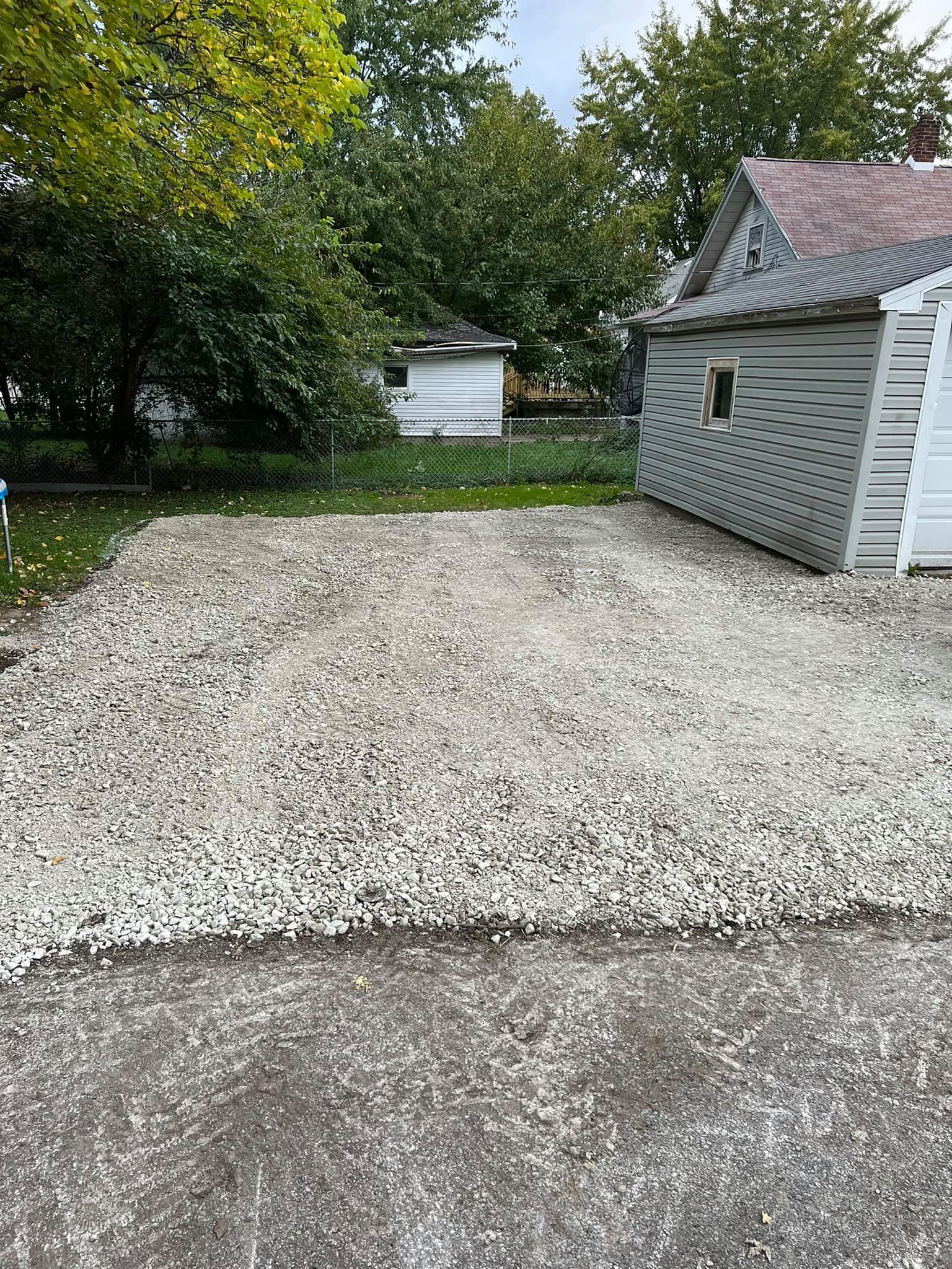 A gravel driveway with a shed in the background.