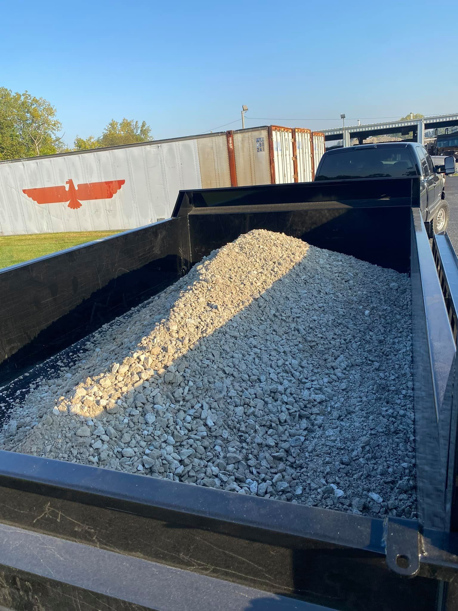 The back of a dump truck filled with gravel.