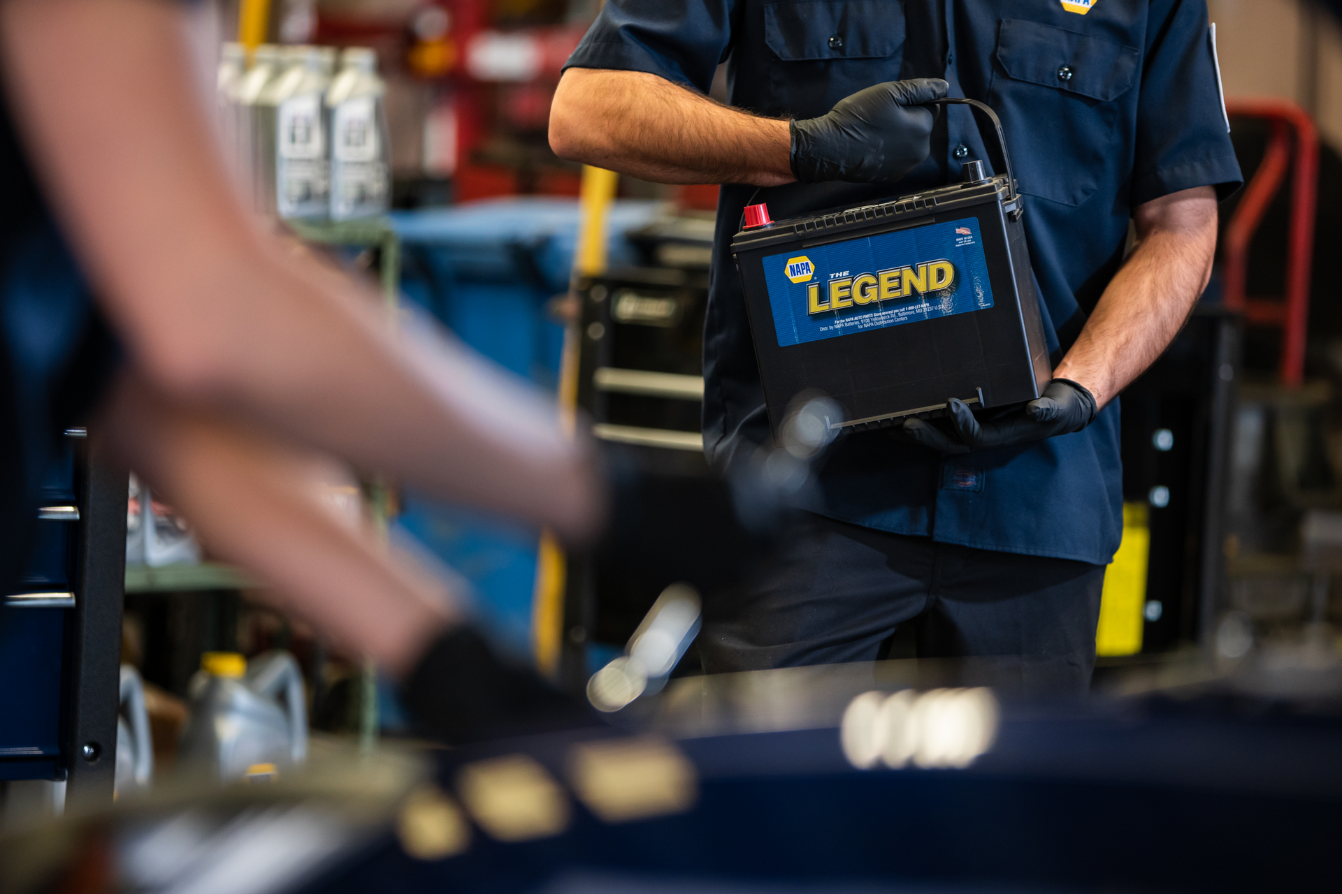 Technician in blue shirt holding a Legrand tool bag in a workshop