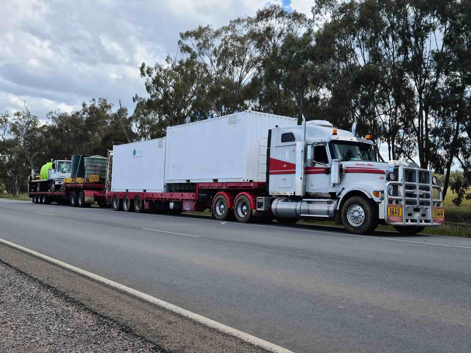 A Semi Truck Is Driving Down A Highway With A Trailer Attached To It — Equiptranz In Kybong, QLD