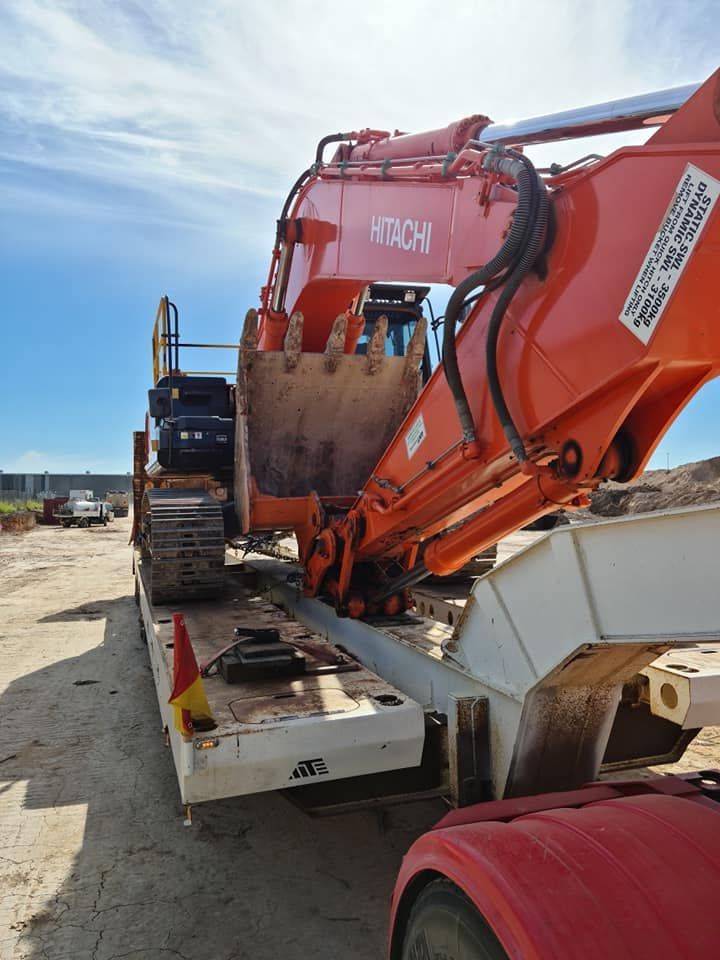 A large orange excavator is sitting on top of a trailer. — Equiptranz In Kybong, QLD