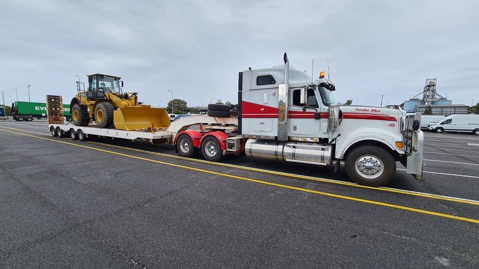 A Semi Truck Is Carrying A Bulldozer On A Trailer — Equiptranz In Kybong, QLD