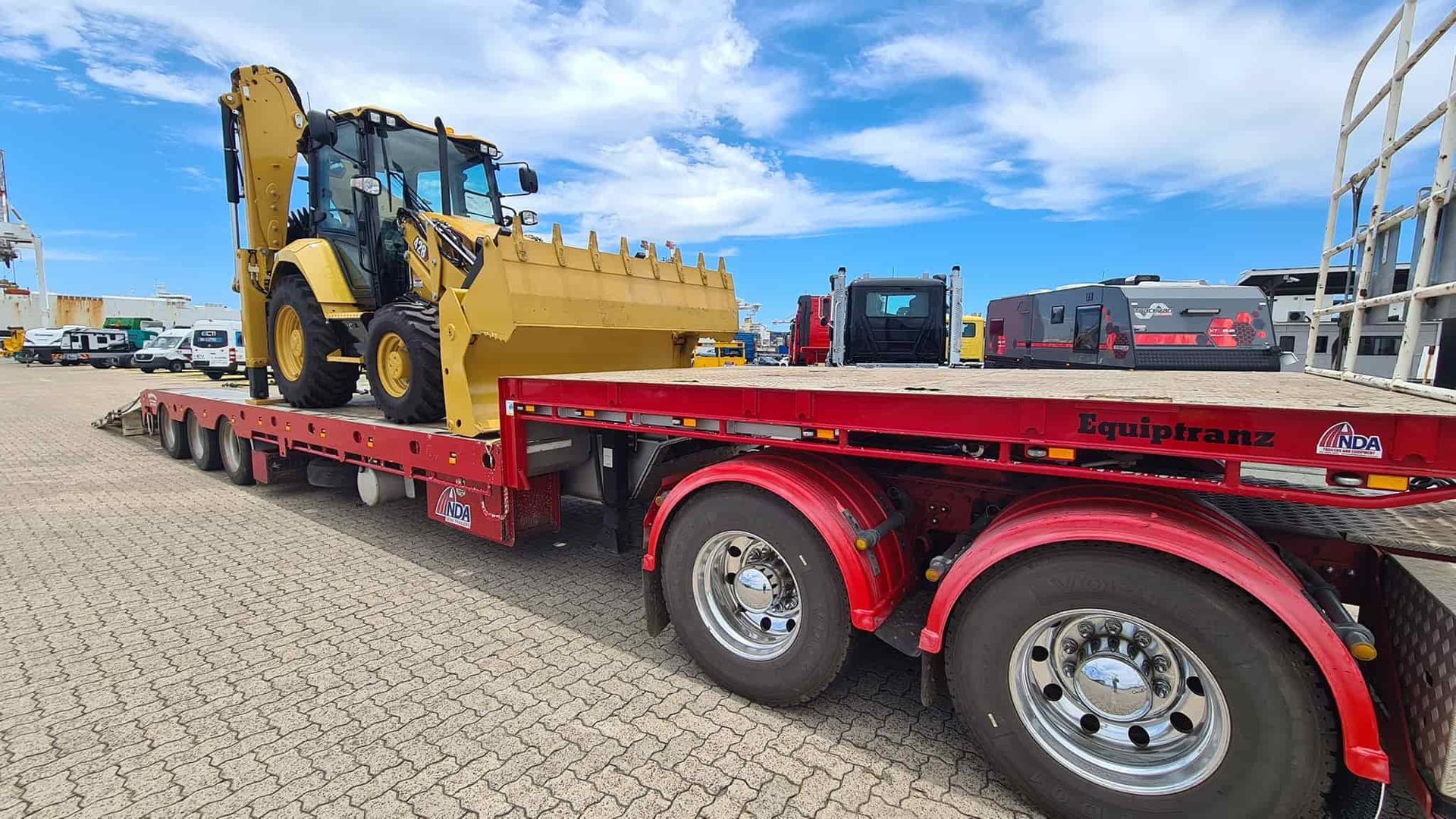 A Red Semi Truck Is Carrying A Bulldozer On A Flatbed Trailer — Equiptranz In Kybong, QLD