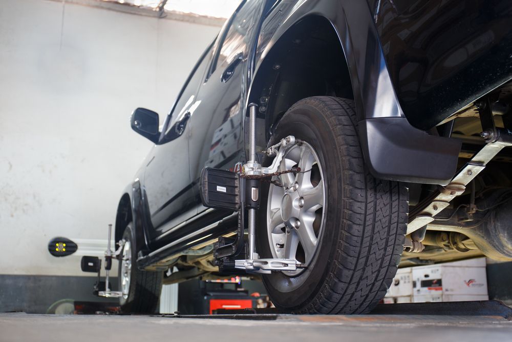 A Black Truck Undergoing Wheel Alignment at a Repair Shop — Pelican Motors Service Centre in Caloundra West, QLD