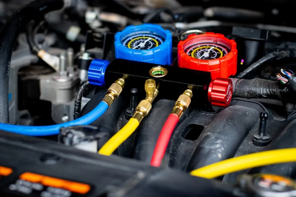 Close-up of car engine with A/C gauges connected by colorful hoses for diagnostic testing. — Pelican Motors Service Centre in Caloundra West, QLD