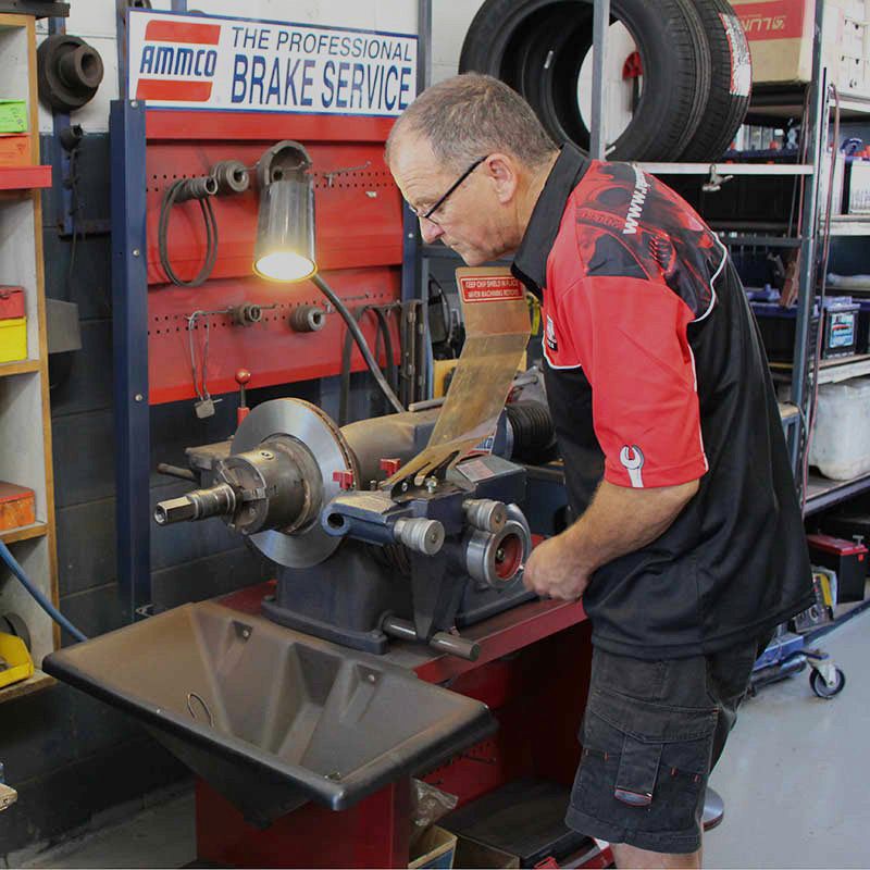 A Man is Working on a Brake Service Machine — Pelican Motors Service Centre In Caloundra West, QLD 