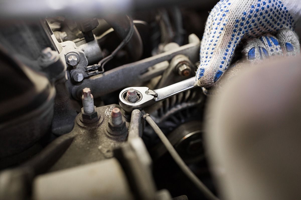 A Person is Working on a Car Engine With a Wrench — Pelican Motors Service Centre In Caloundra West, QLD 