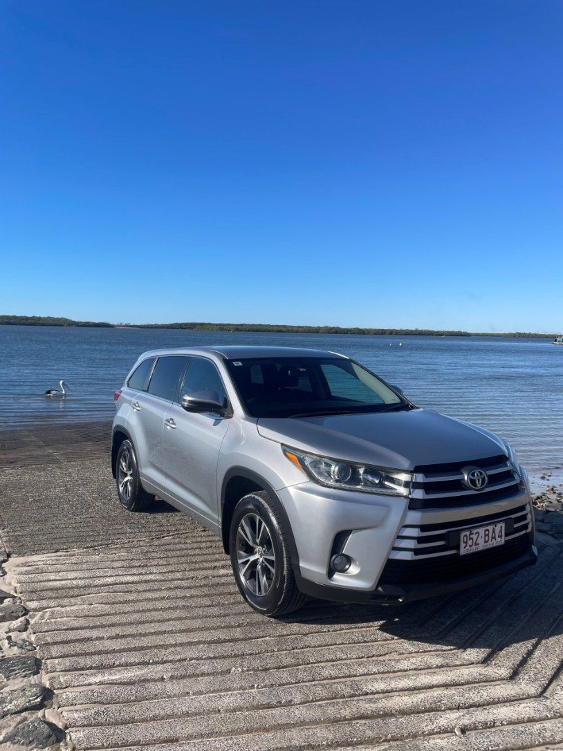 A Silver Toyota Highlander is Parked on a Wooden Ramp Next to a Body of Water โ Pelican Motors Service Centre In Caloundra West, QLDย