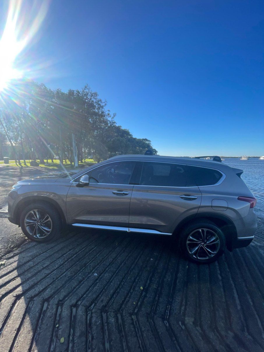 A Silver Hyundai Santa Fe is Parked on a Dock Next to a Body of Water — Pelican Motors Service Centre In Caloundra West, QLD