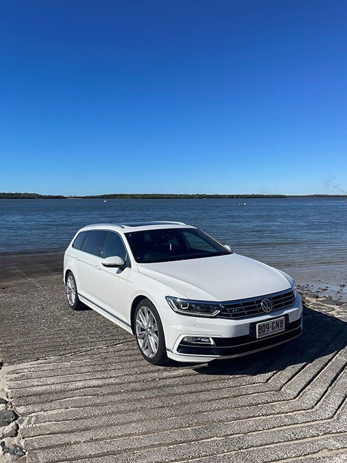 A White Car is Parked on a Dock Next to a Body of Water โ Pelican Motors Service Centre In Caloundra West, QLDย