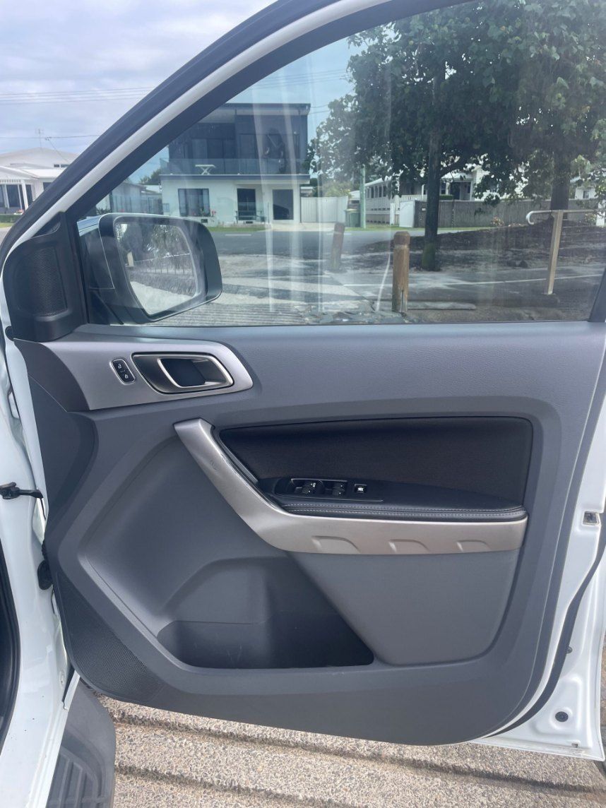 A White Car With the Door Open is Parked on the Side of the Road β Pelican Motors Service Centre In Caloundra West, QLD
