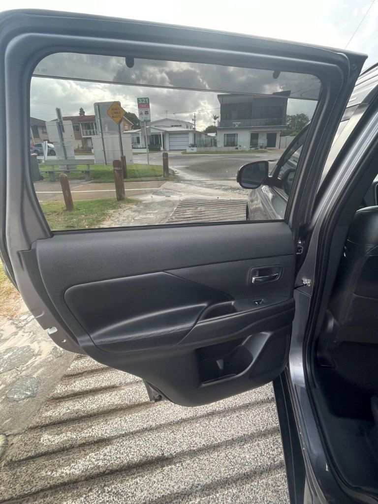 The Back Door of a Car is Open and There is a Reflection of a Building in the Window — Pelican Motors Service Centre In Caloundra West, QLD