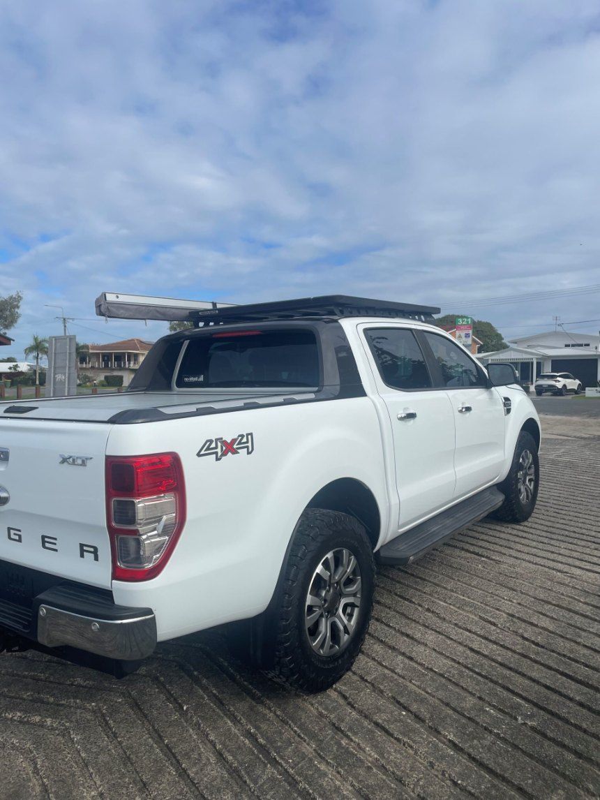 A White Truck With a Roof Rack on Top of It is Parked in a Parking Lot β Pelican Motors Service Centre In Caloundra West, QLD