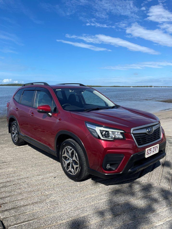 A Red Subaru Forester is Parked Next to a Body of Water — Pelican Motors Service Centre In Caloundra West, QLD 