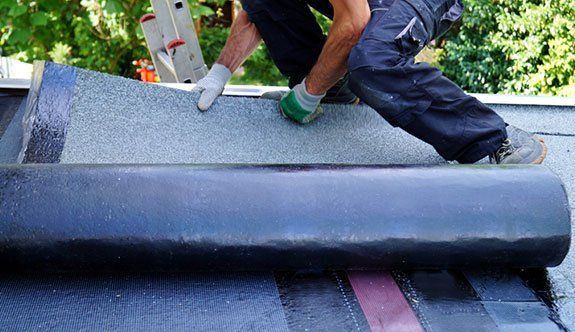 Man Working on Flat Roof Installation — Lakeport, CA — Lucerne Roofing & Supply Corp Man Working on Flat Roof Installation — Lakeport, CA — Lucerne Roofing & Supply Corp