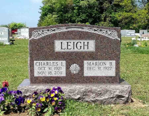 Leigh family gravestone with flowers in a cemetery, showing names Charles and Marion B.