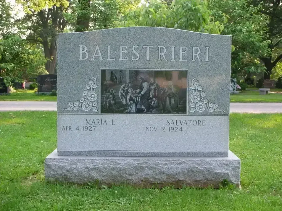 Granite memorial monument in a park with the name “BALESTRIERI” engraved on top and a photo plaque