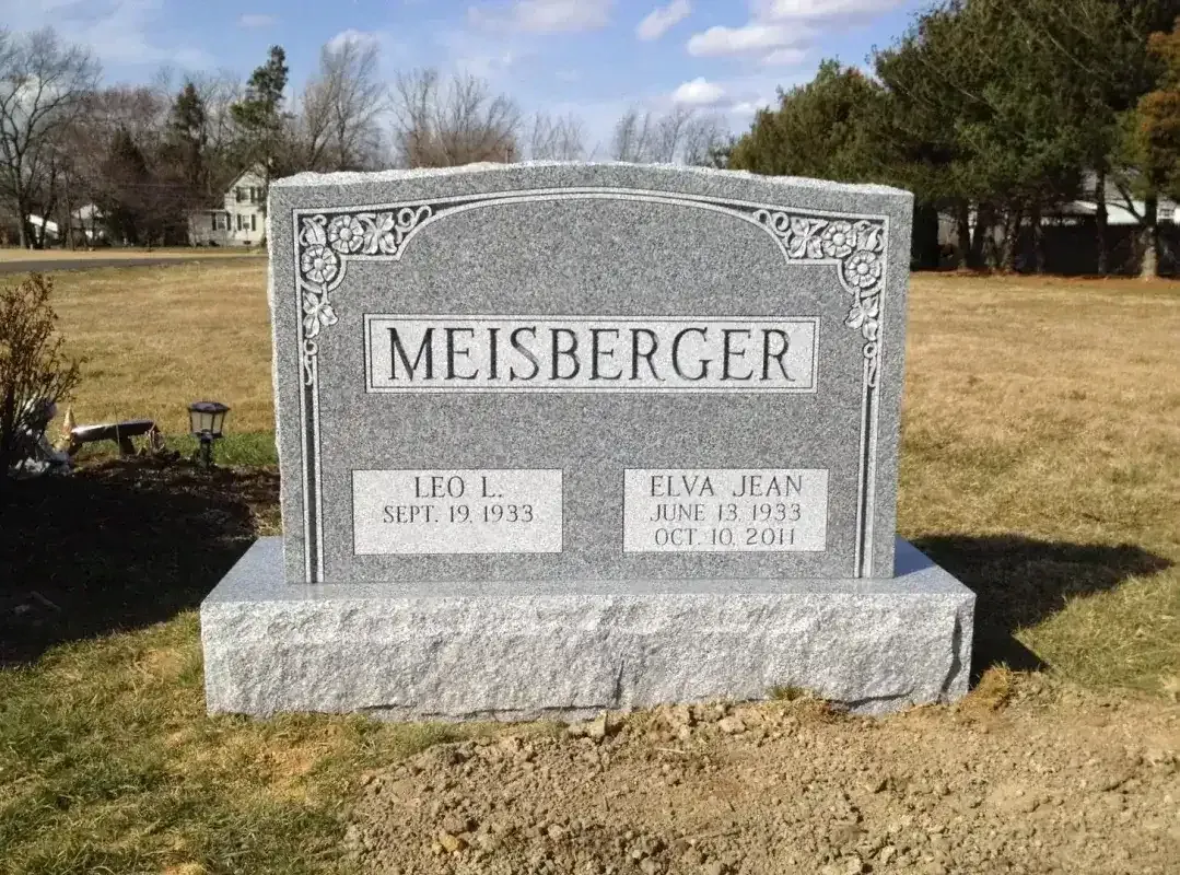 Meisberger gravestone in a grassy cemetery under a blue sky