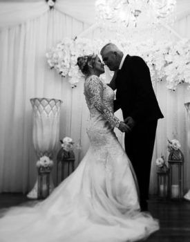 A bride and groom are kissing in a black and white photo.